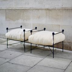 two white chairs sitting next to each other on a sidewalk