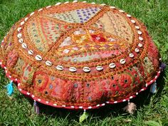 a decorative round pillow sitting in the grass