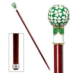 a red and gold colored cane with an ornate design on the top is next to a white background