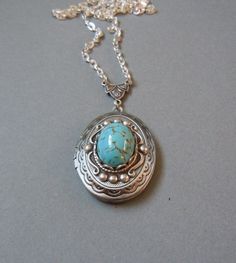 "I set a stunning Beautiful Turquoise Glass Cabs cabs in a classic oval locket in antiqued silver. The locket has a simple vintage-inspired design engraved on the front and back. The locket is 1.25\" X 1\" (3 cm X 2.5 cm) with space inside for you to place your special photo. The locket is connected to a 24-inch chain by a rosary-style connector. The locket is packaged in a lovely little silhouette box, set on a soft piece of white cotton. ♥ * ♥ * ♥ * ♥ * ♥ * ♥ * ♥ * ♥ © Original design by Twili Turquoise Locket For Wedding Jewelry, Turquoise Locket Jewelry For Wedding, Blue Oval Locket Necklace, Oval Blue Locket Necklace, Turquoise Wedding Locket Jewelry, Elegant Turquoise Locket Jewelry, Turquoise Round Pendant Locket Jewelry, Elegant Turquoise Locket Necklace, Oval Locket For Vintage Jewelry Collection