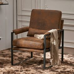 a brown leather chair sitting on top of a rug