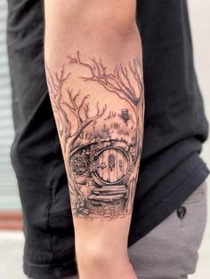 a man with a tattoo on his arm has a tree and a hobbot