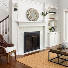 a living room filled with furniture and a fire place next to a stair case in front of a window