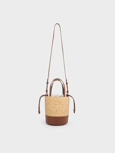 Rock the resort-chic aesthetic all summer long with this stunning bucket bag. It has all the makings of a warm-weather classic, from its beautiful woven finish to its standout colours and stylish practicality. The brown leather bottom creates a striking contrast with the woven body, providing extra structure and stability. The drawstring closure allows for quick and easy access to your belongings while keeping them secure. Raffia Bucket Bag, Resort Chic, Chic Aesthetic, Charles Keith, Easy Access, Warm Weather, Bucket Bag, Brown Leather, Handbags