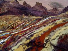 an aerial view of colorful rocks and trees in the distance with mountains in the background