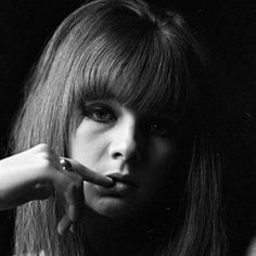 a black and white photo of a woman brushing her teeth with a toothbrush in front of her face