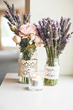 two vases filled with flowers sitting on top of a table