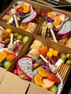 two boxes filled with assorted fruits and crackers on top of each other,