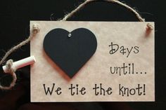 a black heart hanging from a string with the words days until we're the knot