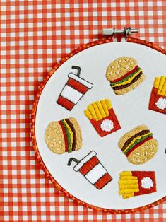 a close up of a embroidery on a piece of cloth with different foods and drinks