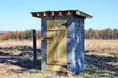 a small outhouse in the middle of a field