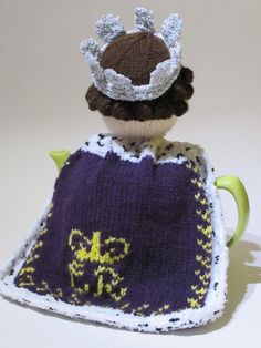 a knitted tea cosy with a crown on top