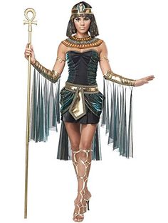 an egyptian woman dressed in costume and holding a staff with both hands on her hip