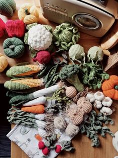 many crocheted vegetables are laying on a table next to a toaster oven