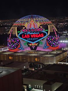 an aerial view of the las vegas sign at night with city lights in the background