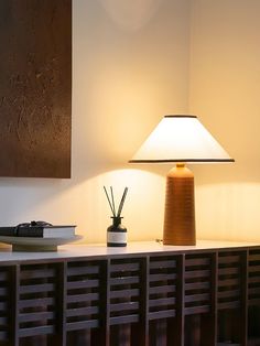 a table lamp sitting on top of a wooden shelf