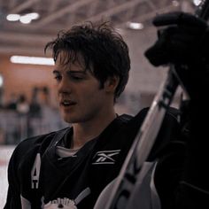 a young man holding a hockey stick in his hand