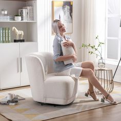 a woman sitting in a chair holding a pillow