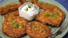 a plate with some fried food on it and a small bowl of ranch dressing next to it