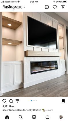 an empty living room with a large flat screen tv mounted above the fireplace and built - in shelving