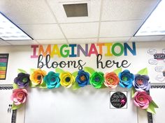 an office decorated with colorful paper flowers and congratulations blooms here written on the front wall