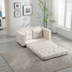 a living room with a white couch and ottoman on the floor in front of a window