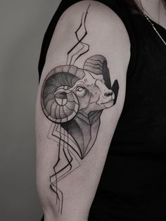 a woman's arm with a ram tattoo on the left side of her arm