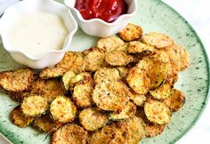 a plate topped with fried zucchini next to a bowl of ketchup