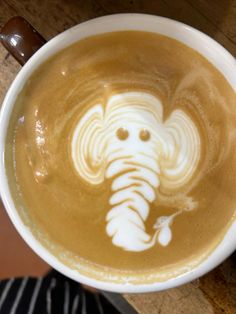 a cup of coffee with an elephant drawn on it