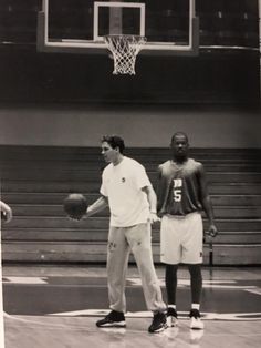 an old photo of two men playing basketball