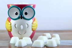 an owl figurine next to marshmallows on a table