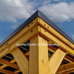 the top of a wooden structure with metal roofing and sky in the back ground