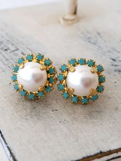 "Pearl stud earrings, Turquoise European halo and white pearl stud earrings, Bridesmaid gifts, Bridal earrings, Gold post earrings, crystal Lovely and chic. These earrings are so sweet and romantic. They would be great for bridal earrings or for any available other day. Perfect gift for bridesmaids or any available other occasion. They are made of 14k gold plated post studs, genuine Swarovski white pearls and turquoise Swarovski tiny rhinestones, all set in prong setting. Made with CRYSTALLIZED™ Pearl Bridesmaid Earrings, Turquoise Pearl Earrings, Pearl Bridal Earrings, Bridesmaid Pearl Earrings, Bridesmaid Pearls, Turquoise Stud Earrings, Bridal Earrings Pearl, Pearl Bridal, Earrings Turquoise