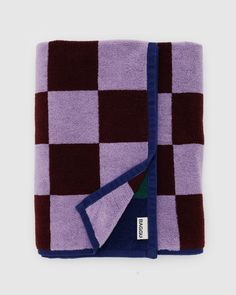 the purple and blue checkered blanket is folded up