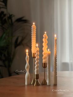 candles are lined up on a wooden table