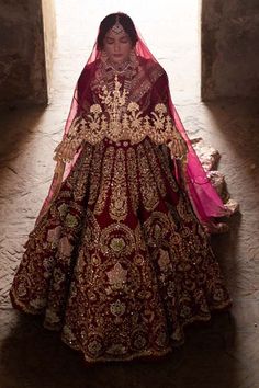 a woman in a red and gold wedding dress