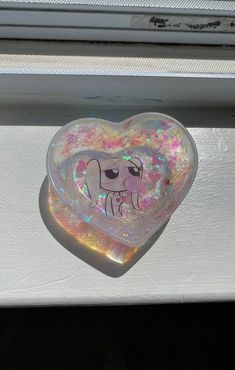 a heart shaped object sitting on top of a window sill