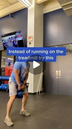 a man in blue shirt and gray shorts holding a baseball bat while standing in front of a tv