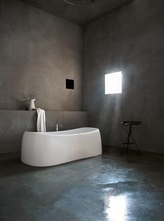 a white bath tub sitting in a bathroom next to a window