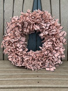 a pink wreath sitting on top of a wooden bench