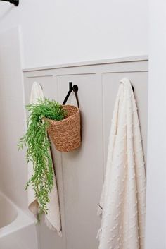 a bathroom with a towel rack and green plant hanging on it's door handle