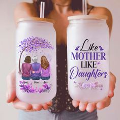 two women holding up personalized water bottles with the words like mother like daughters on them