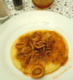 a white plate topped with food on top of a table next to a glass vase