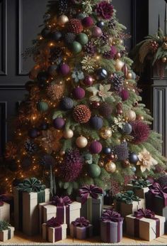 a christmas tree with presents under it and lights on the top is decorated in purple, green and gold