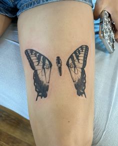 two butterfly tattoos on the legs of a woman's leg, one is black and white