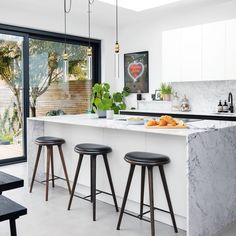 a kitchen with marble counter tops and stools