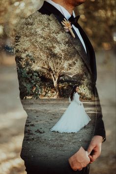 a man in a tuxedo is standing next to a tree