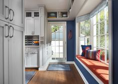 a kitchen with white cabinets and blue walls