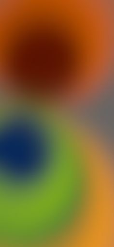 a blurry image of an orange, green and blue circular design on a gray background