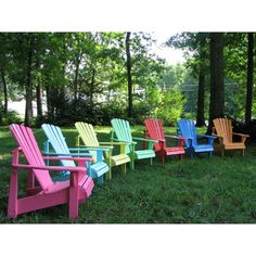 a row of colorful chairs sitting in the grass